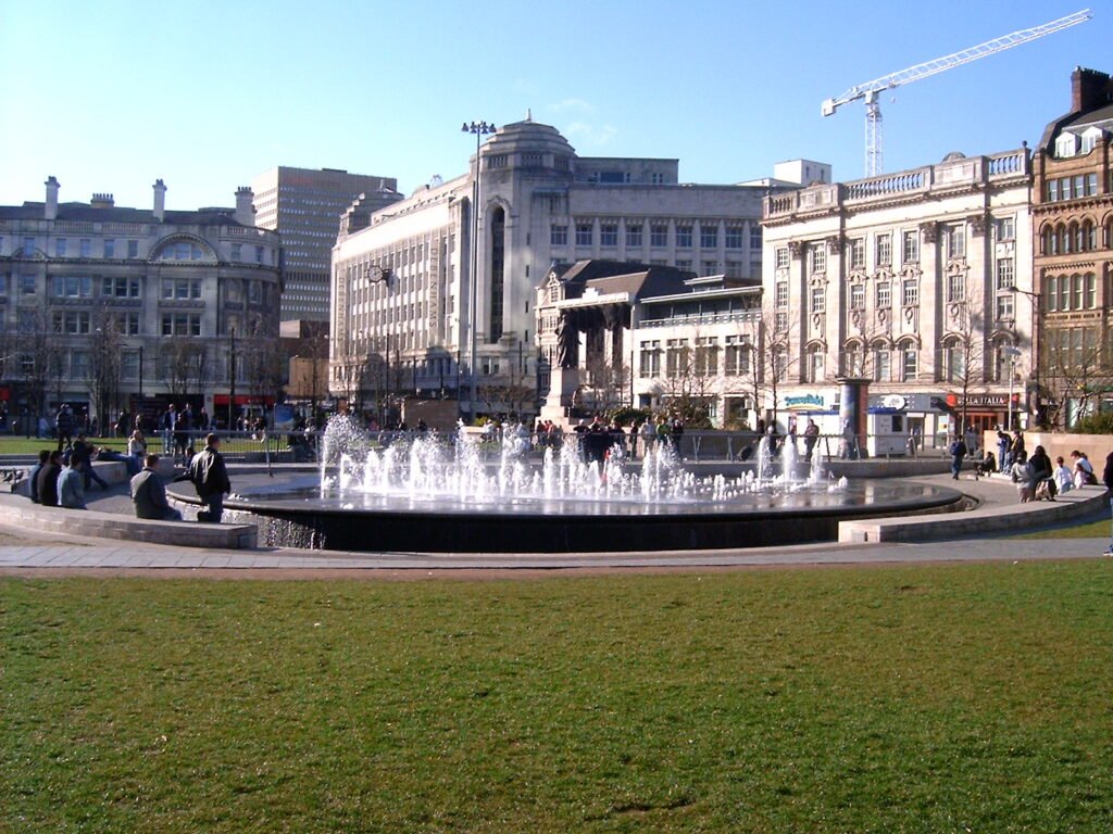 Piccadilly Gardens in Manchester city centre with trams passing