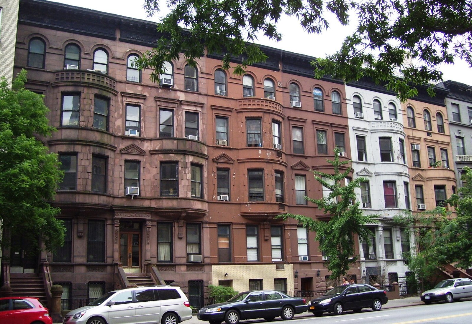A row of brownstone townhouses on a tree-lined Upper West Side street