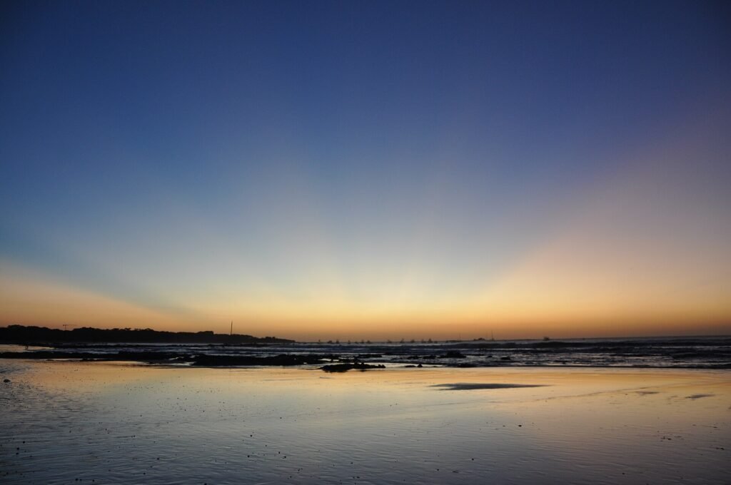 Surfers and beachgoers on the wide sandy beach at Tamarindo in Guanacaste