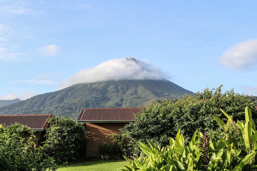 The conical peak of Arenal Volcano rising above rainforest and farmland